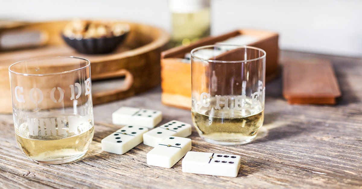 Etched Wine Glasses on a table with dominos